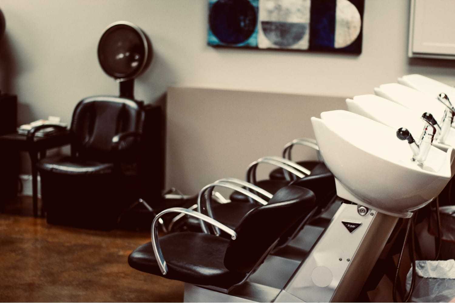 Hair salon with empty washing stations and styling chairs.